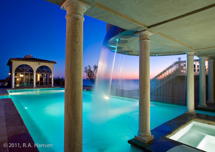 Residents enjoy a summer ocean-view sunset while relaxing by this elegant residential pool complete with illuminated waterfall...