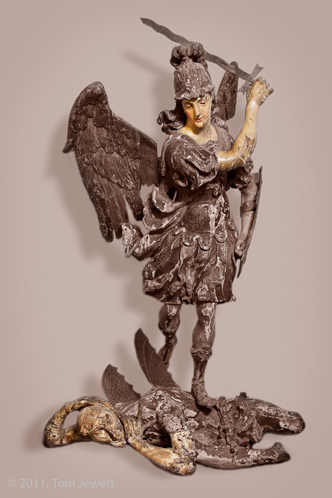 Life-size wood carving of the Archangel St. Michael slaying the Devil, allegorically representing the victory of good over evil...